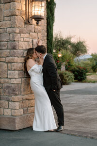A man and woman holding each other while they look into each others eyes and smile at each other at Monte de Oro Winery in Temecula, California. 