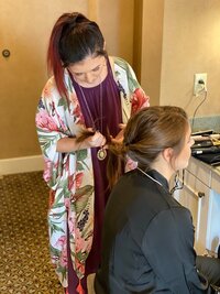 Caitlin braiding a clients hair