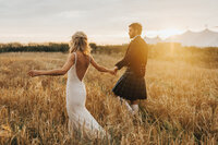 bride and groom holding hands at golden hour