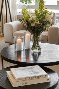 Donkergroene kast met tegels daarboven kussen en woonaccessoires