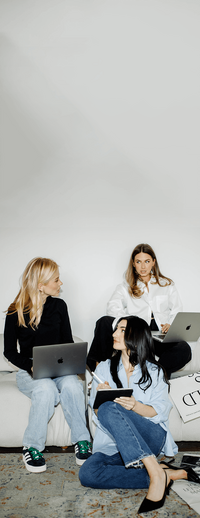 Three women meeting with their laptops discussing projects