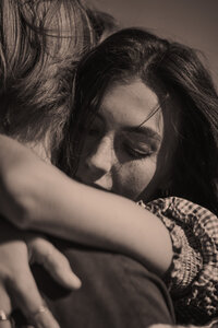 A girl clings to her boyfriend as they dance in a train yard.