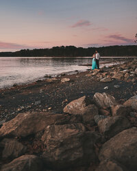 Couple looking out onto a lake at sunset