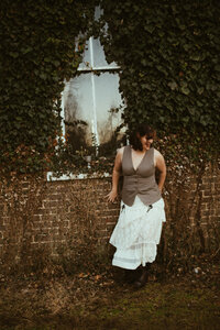 Kenna Leaning against a brick wall.