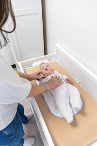 Women holding her baby on the changing table