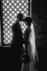 black and white image bride and groom kissing
