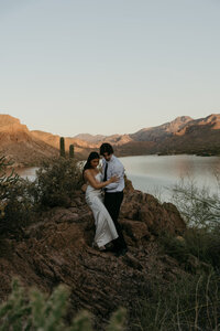 bride and groom climbing over rocks at destination wedding in arizona