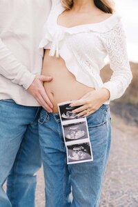 Husband holds wife's pregnant belly at Seven Islands State Birding Park in Kodak Tennessee