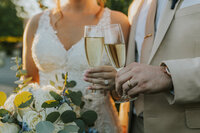 rebecca skidgel photography sacramento wedding photgrapher scribner bend vineyards couple rings holding champagne