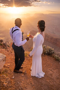 A bride and groom exchanging vows with the Grand Canyon sunset casting warm golden hues across the scene.