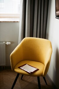 yellow chair with a notepad on top of it