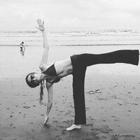 A woman in a Half Moon pose (Ardha Chandrasana), a yoga posture that demonstrates balance and strength.