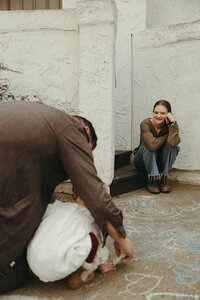 Mom looking lovingly at her husband playing with their daughter with sidewalk chalk, Intimate Wedding, Elopement, and Family Photography NYC and Western North Carolina Area