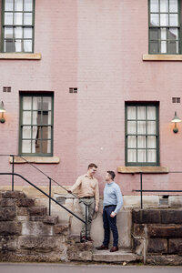 same sex male couple in front of pink wall in the rocks, sydney