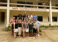 Teachers take a picture in front of an American school in Vietnam.