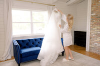 Bride hanging up her wedding dress in her bridal suite.