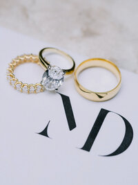 gold engagement ring and wedding rings for flatlay