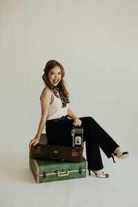 woman sitting on suitcase