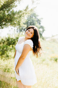 Portrait of a senior girl in an orange top and white pants