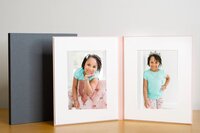 Little girl in teal shirt displayed in open folio.