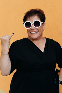 A woman member of the LIVE BIG Collective posing confidently with sunglasses on 