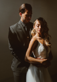 Bride and groom holding onto each other in romantic lighting