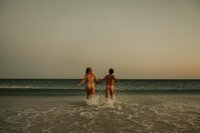 Fine art nude couple running in ocean at Pensacola Florida beach, cinematic moody editorial film & Super 8 photographu