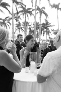 Guests laugh and chat at a reception.