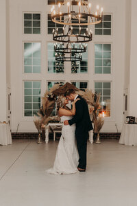 Indoor wedding with kiss in the aisle