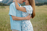 On Chautauqua Trail in Boulder, Colorado, an engaged couple embraces, surrounded by the natural beauty of the trail and the Flatirons.