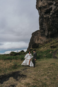 Two newlyweds walk through a grassy area during their Iceland elopement