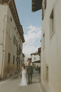 bride and groom walking down street in Italy