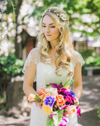Bride holds bouquet and looks down to her right