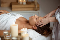 Femme allongee recevant un soin energetique au niveau du visage par apposition des mains