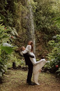 bride and groom in a jungle near a waterfall