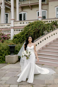 A shot of a bride walking towards the camera with big classic waves holding her bouquet.