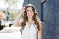 teen girl in white vest smiling for her senior portraits in Los Angeles California