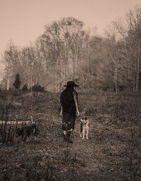 Farmer's daughter in black cowboy hat and all denim pose on an old gravel road.