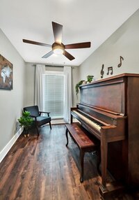 Piano room with hardwood floors in this three-bedroom, two-bathroom vacation rental home featured on Chip and Joanna Gaines' Fixer Upper located in downtown Waco, TX.