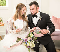 Image of bride and groom admiring their wedding invitations together, showing their happiness and satisfaction