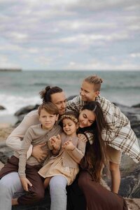 family shoot while parents with their 3 kids on a beach area