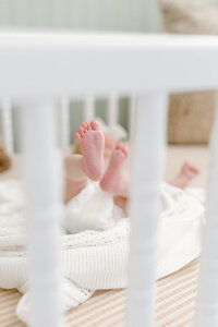 Baby feet through crib rails from photo session with  Indianapolis newborn and family photographer Capturing Simplicity Photography