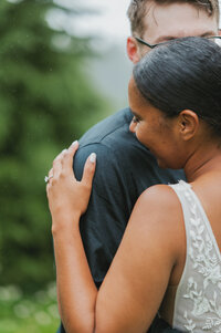 couple cuddle together in the rain