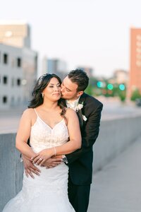 bride and groom hug and kiss on a street in st louis mn