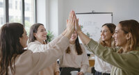 Team of wedding industry professionals doing a high five.