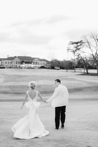 Bride and groom embracing outside in grass