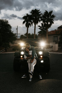 photo of an engaged couple posing in front of their car taken by Lulle Photo, a husband and wife photo and video team
