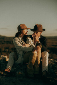 Sunshine Coast elopement photographer capturing a cinematic, intimate moment of a couple wearing Akubra hats, sharing whisky together.