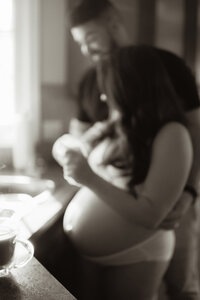 An expecting mother and father standing by a sink documented by a Sudbury Documentary Photographer