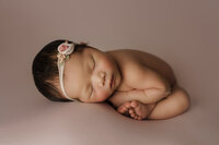 Newborn baby girl in womb pose